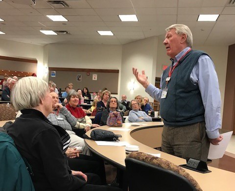 Man lecturing to a class of adults