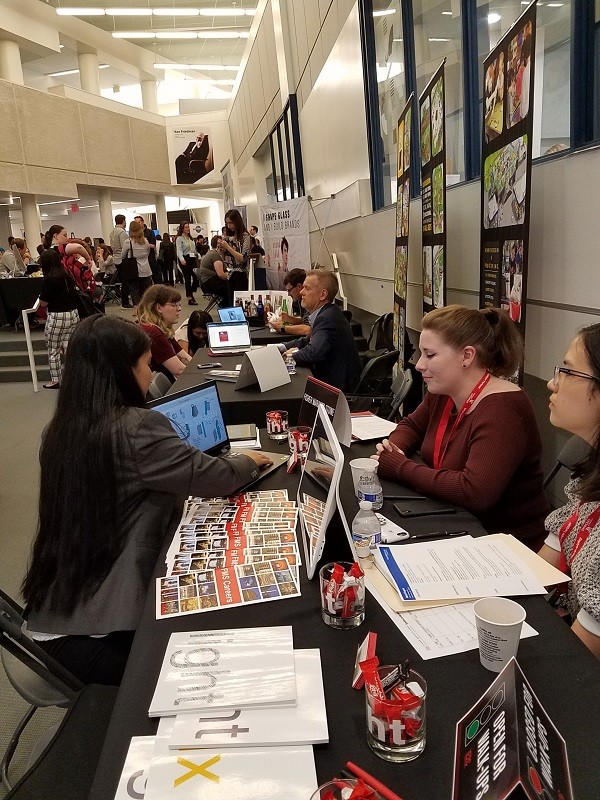 student shows images on a laptop to a person sitting across from her